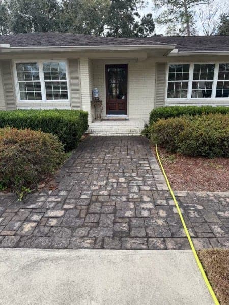 Paver driveway looking gray and dull with organic staining before cleaning