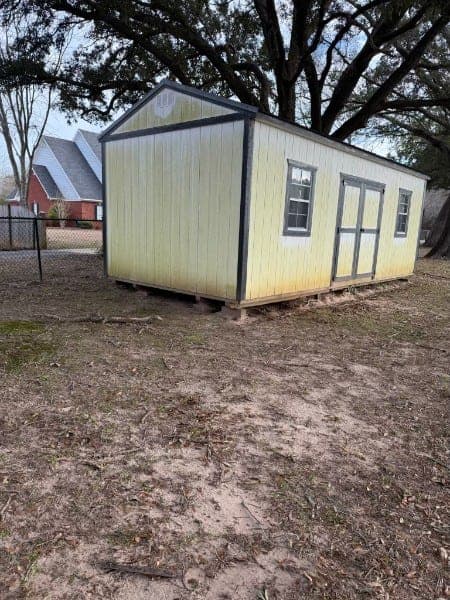 Storage building with dingy, algae-stained walls before soft washing