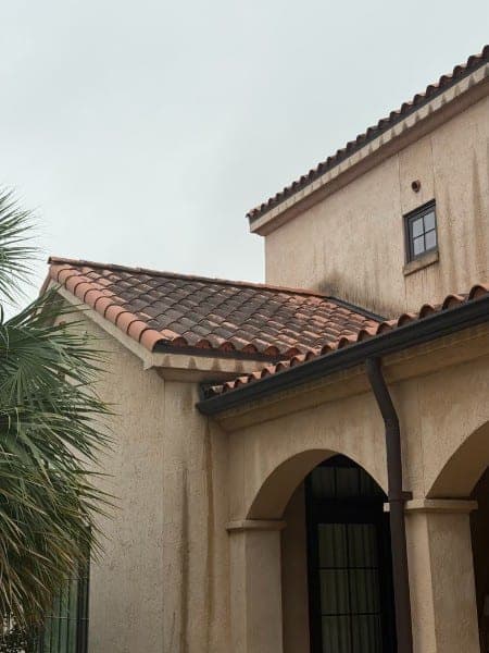 Clay tile roof looking dull and gray-toned from algae growth before cleaning