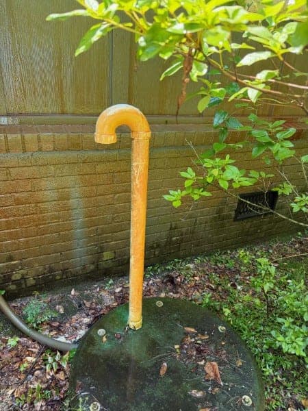Standpipe and wall stained orange-yellow with rust before treatment